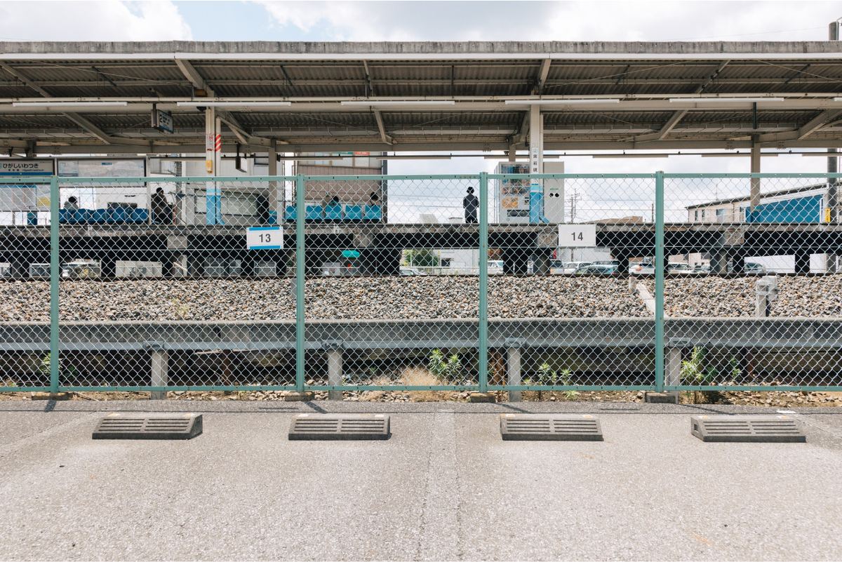 駐車場の13番と14番の区画。フェンスに番号札