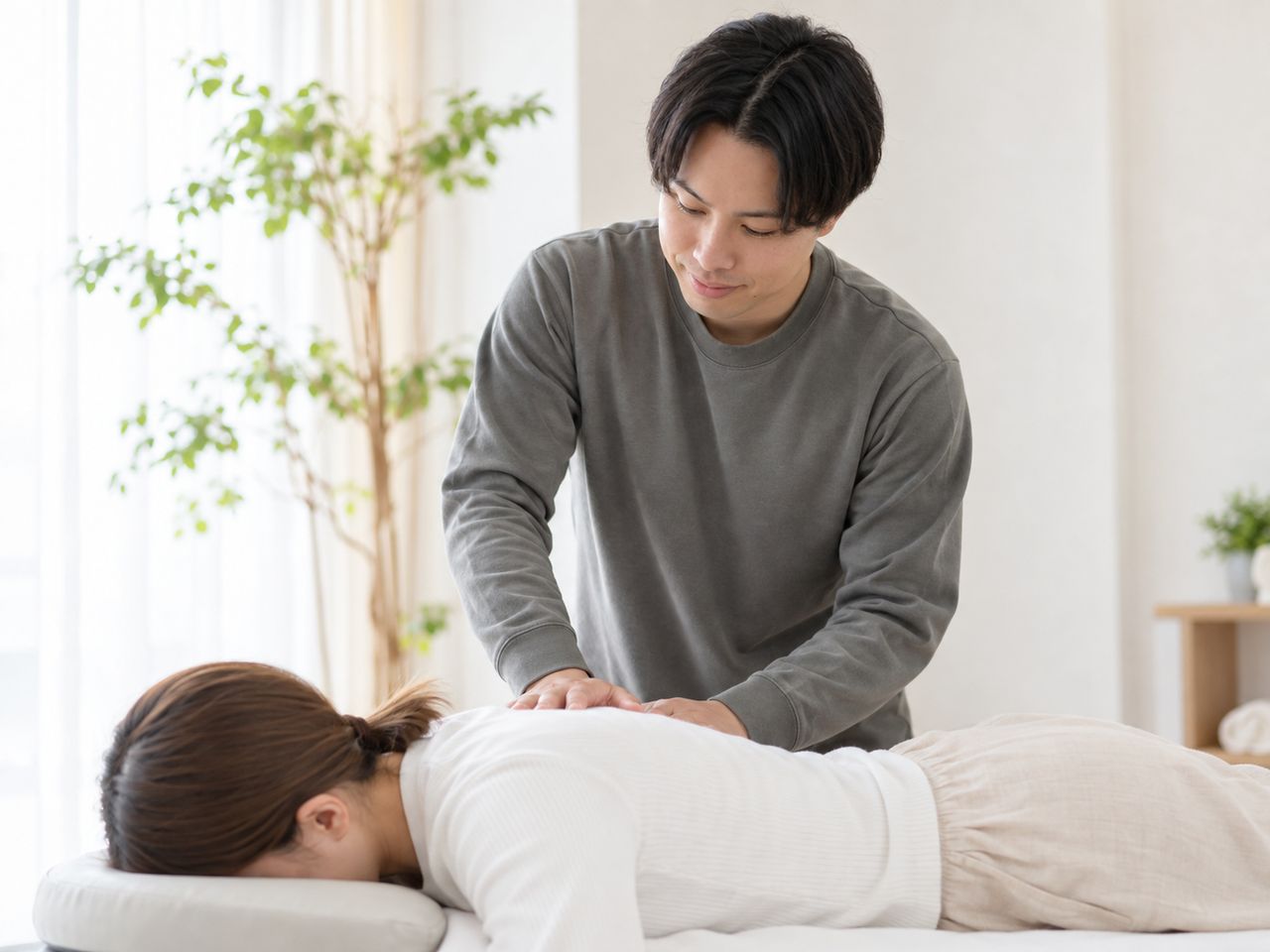 うつ伏せで背中を施術する場面のイメージ